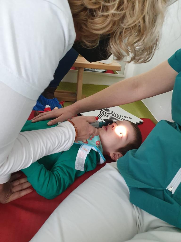 Pilar Vergara realizando un diagnostico de optometría conductual a un niño discapacitado en Rumanía